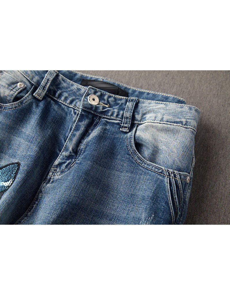 Jeans with sewn-on sequins and butterfly motifs